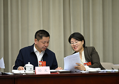 住黔全国政协委员孙发（左）与同组委员交流讨论。.jpg